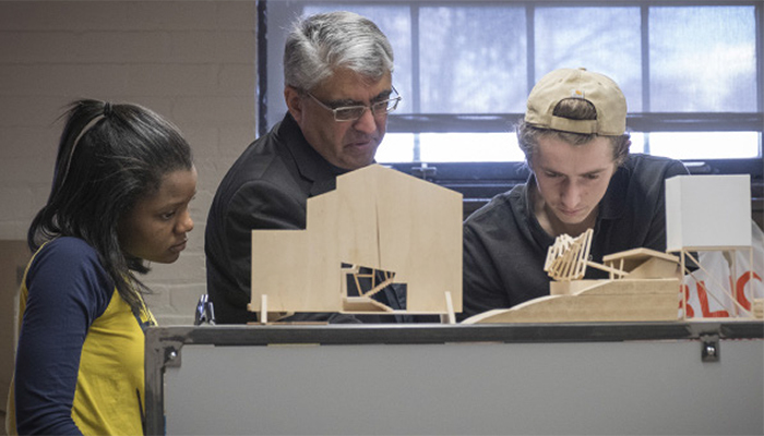 A Detroit Mercy professor and two students look at an architecture project.