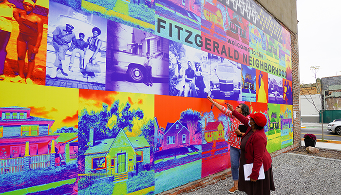 Two women look at a colorful mural for the Fitzgerald Neighborhood