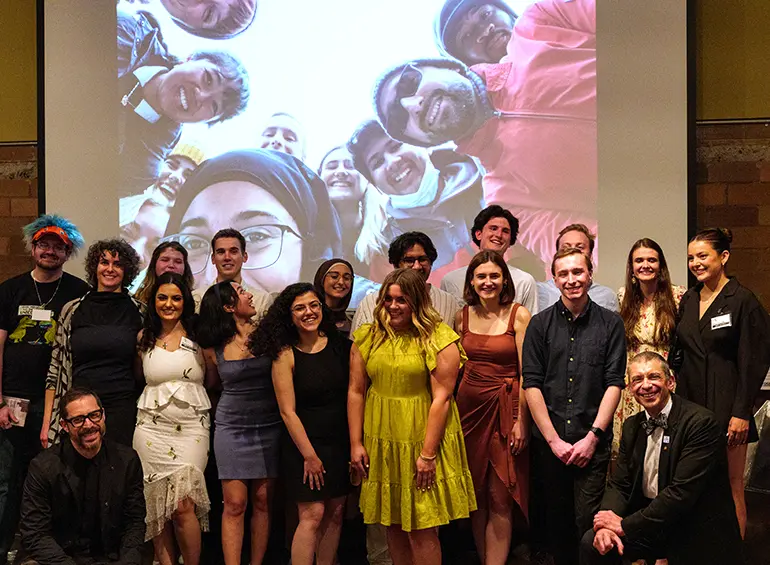 group of students with others on the screen behind them