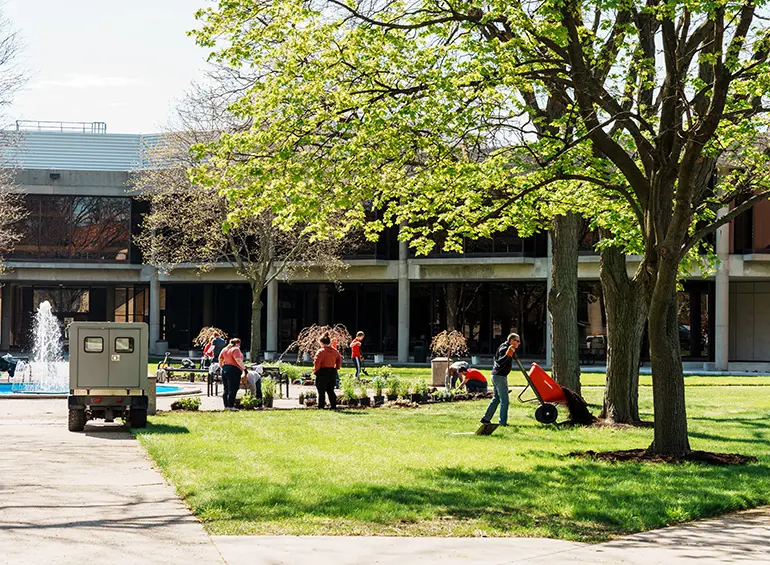 students outside cleaning the area